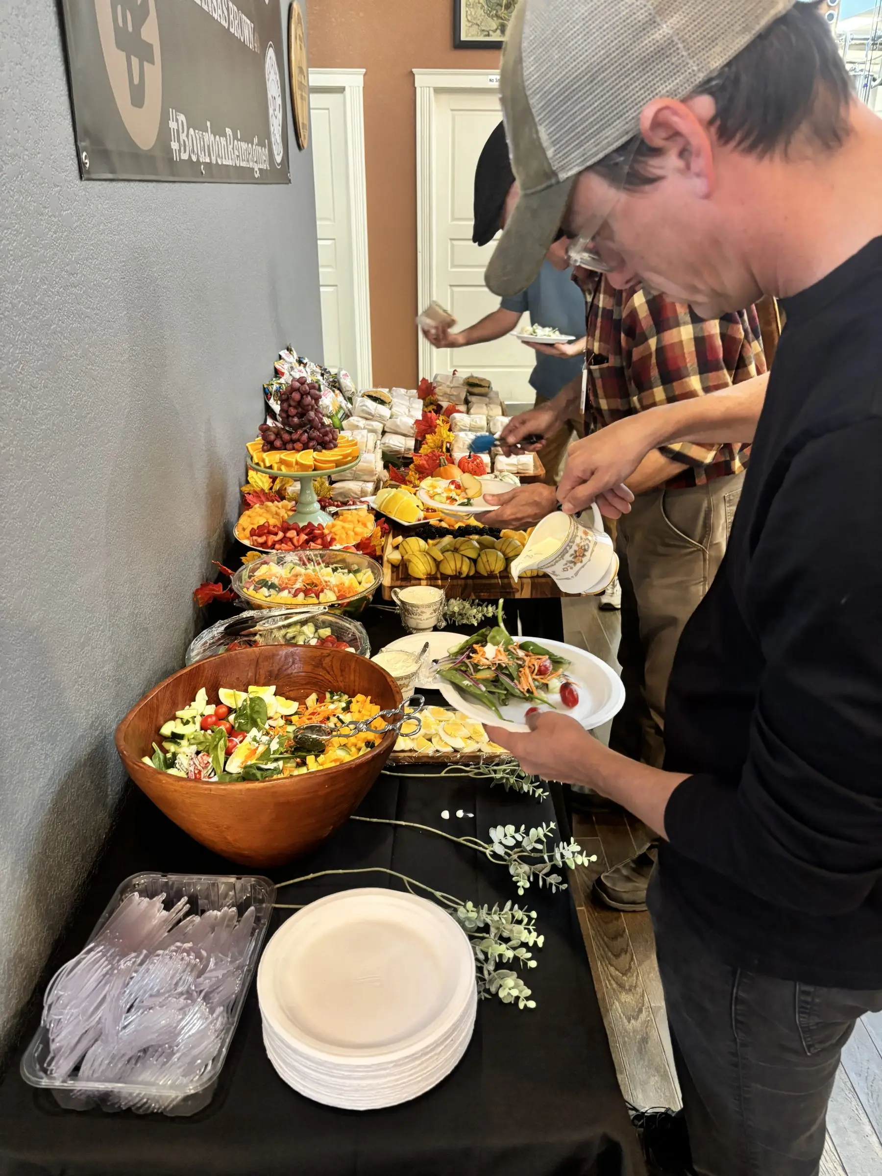 Guests serving themselves chef salad and fruit from the buffet line