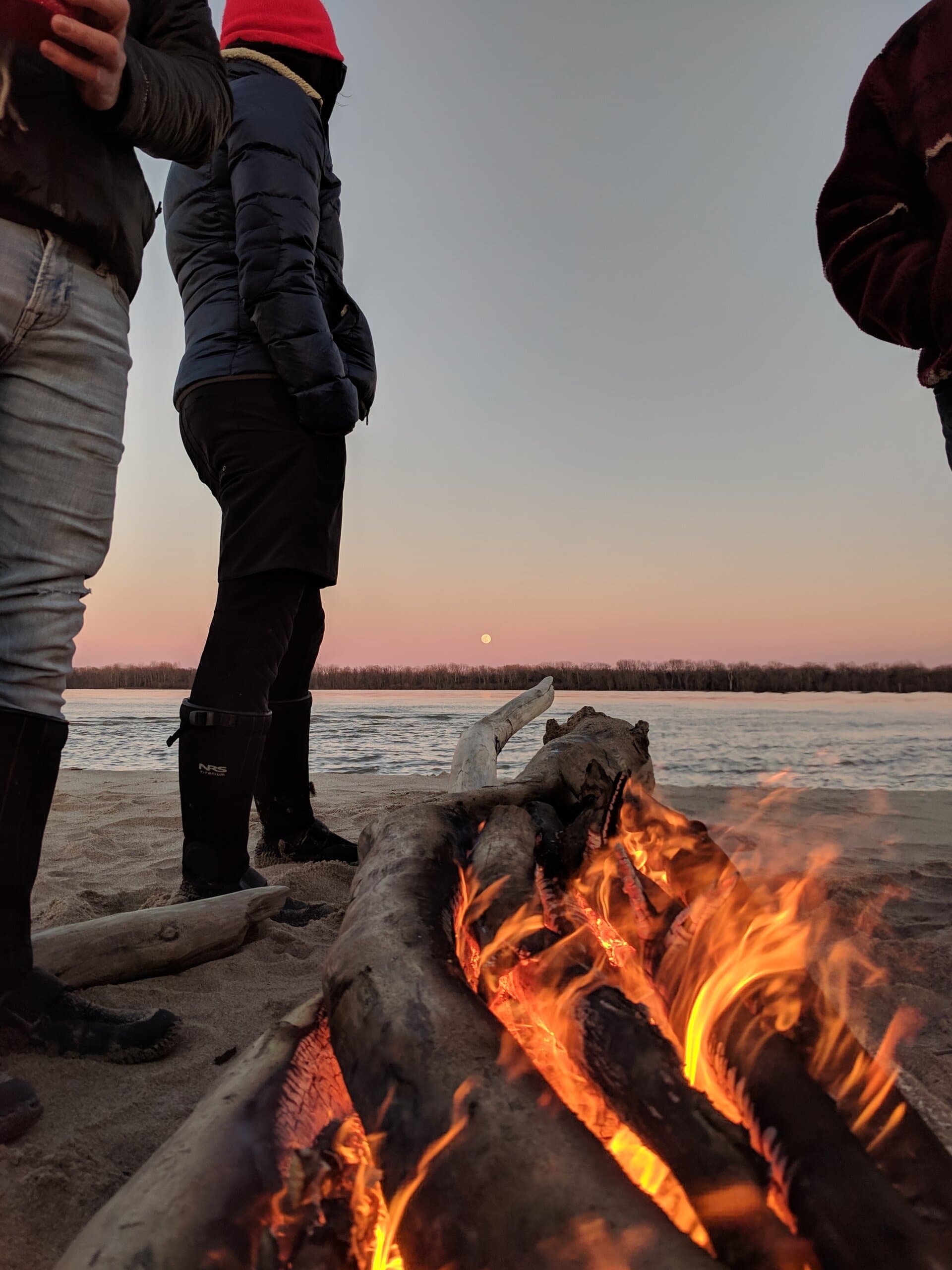 Campfire on Mississippi River sandbar at dusk