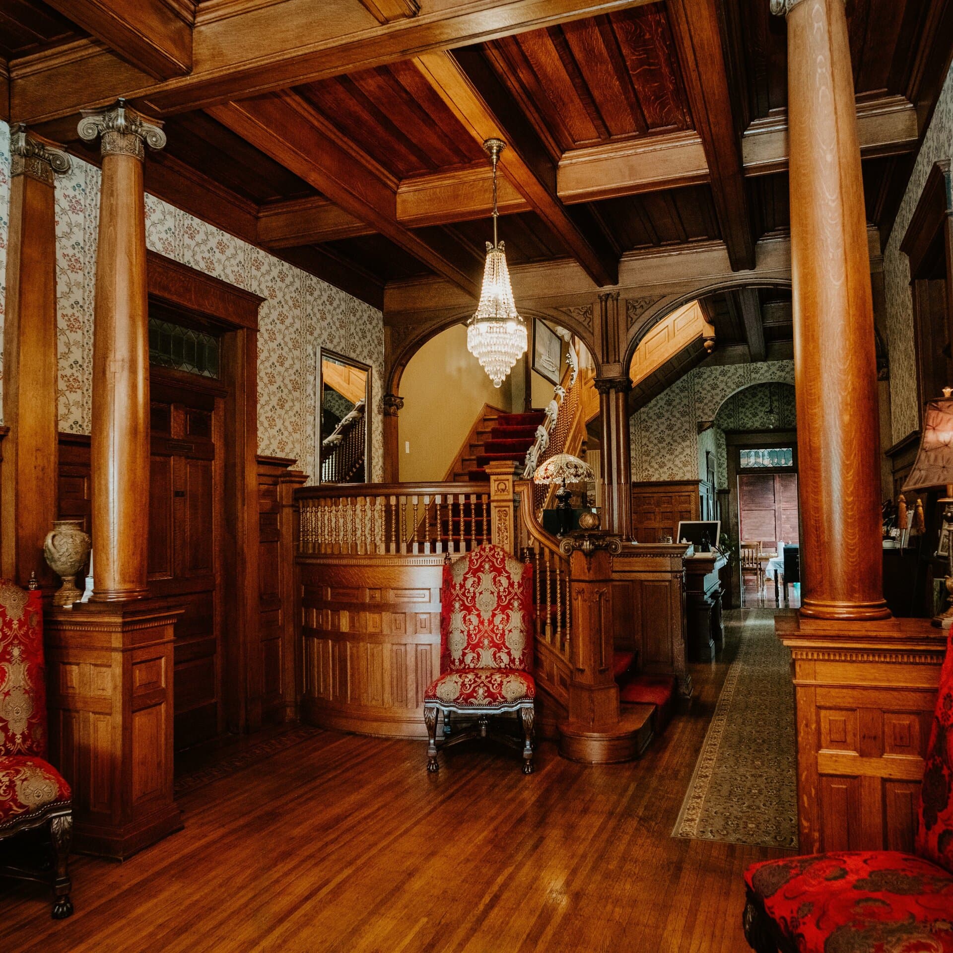The grand foyer with oak staircase and chandelier